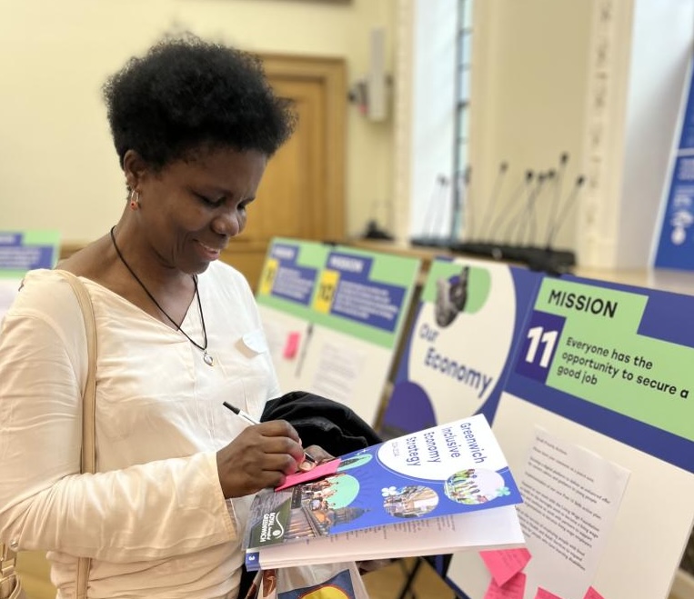 Event attendee with the strategy document on hand, writing suggestions on a post-it note